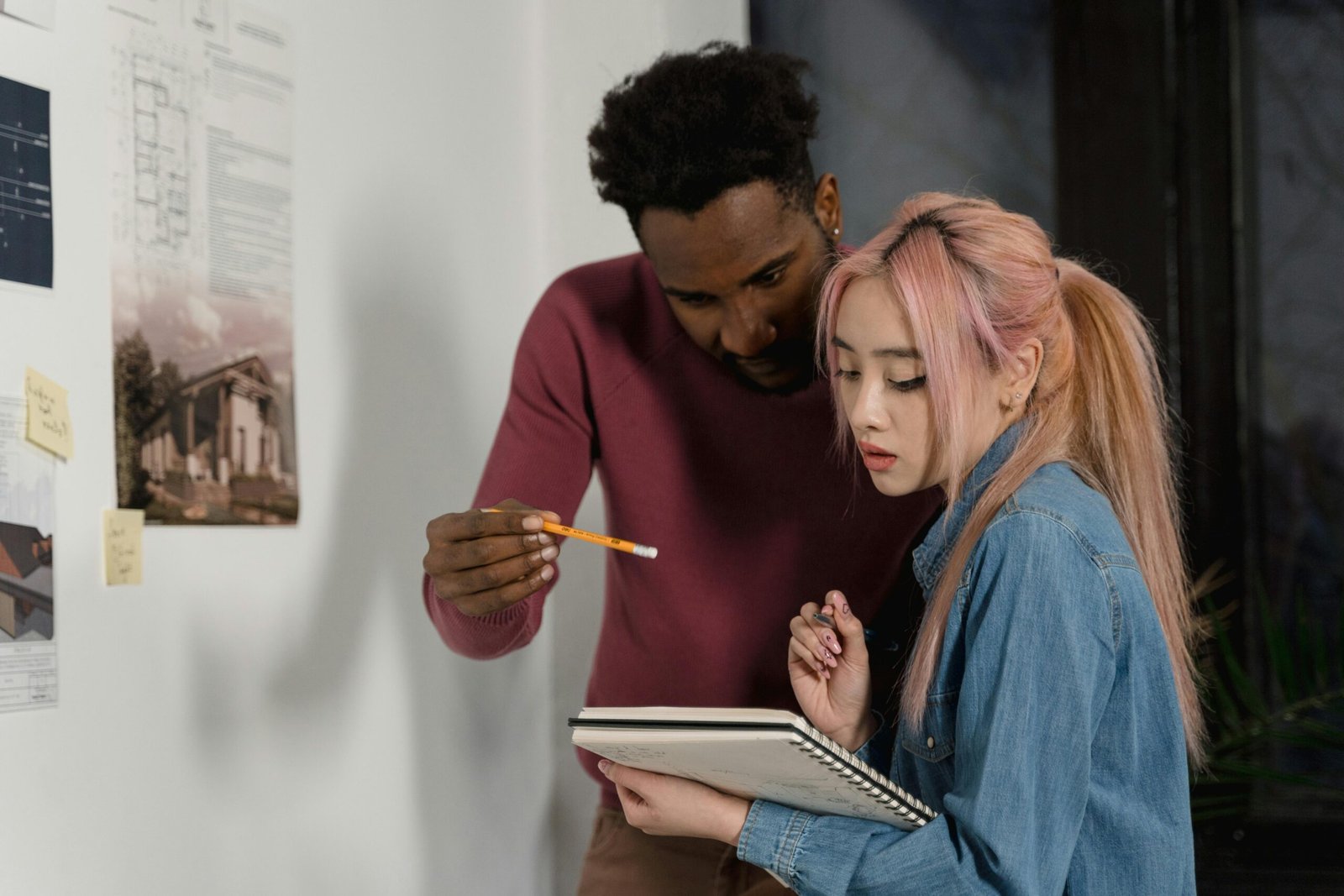 Un professionnel et un client en plein brainstorming devant un tableau