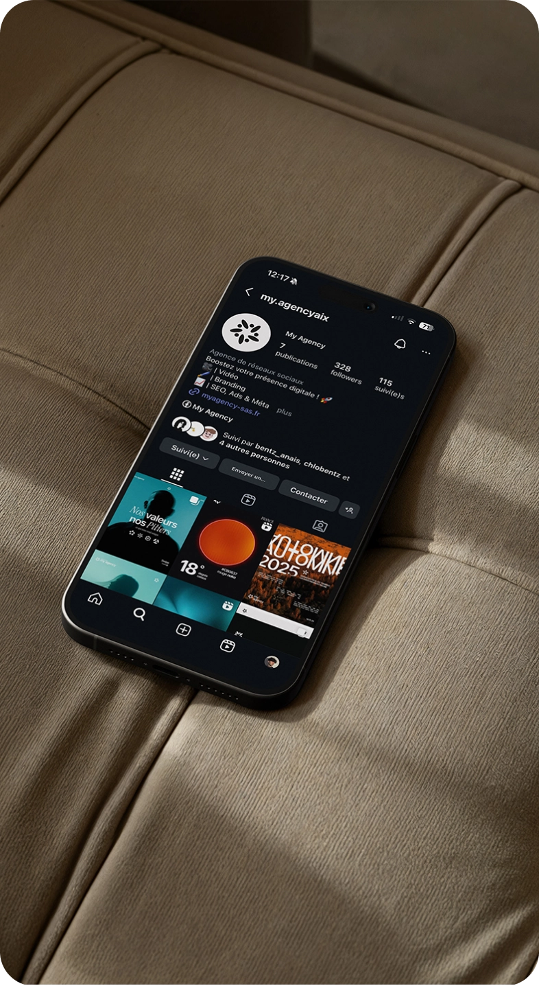 Smartphone posé sur un siège, affichant le profil Instagram de My Agency en mode sombre.